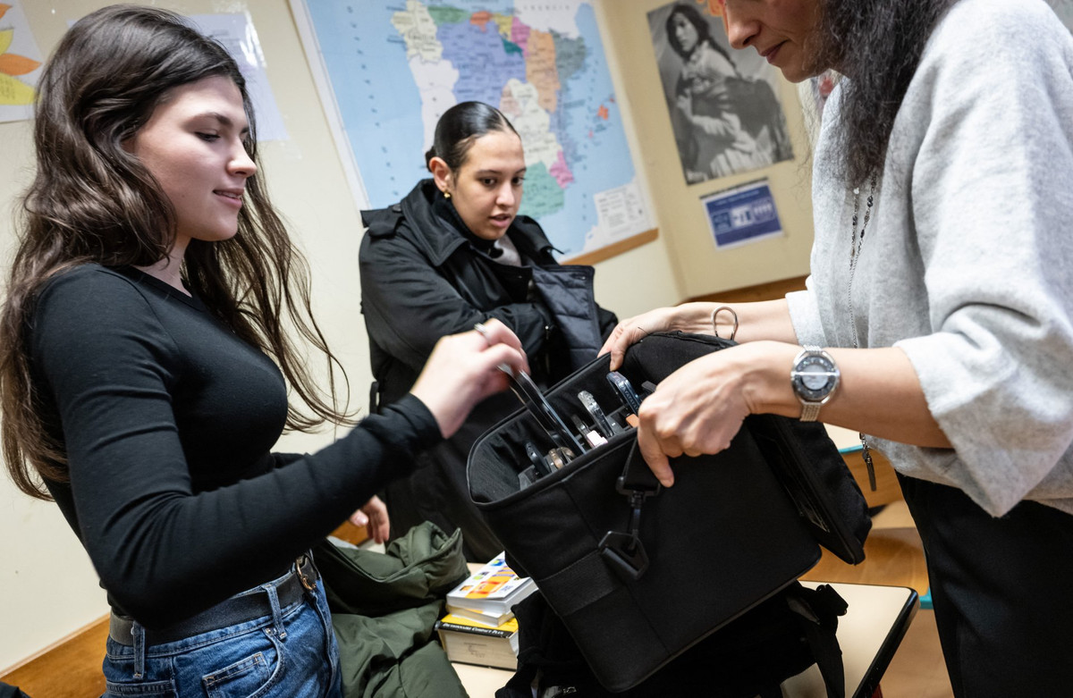 Вчителька паризької школи збирає мобільні телефони учнів перед початком уроку