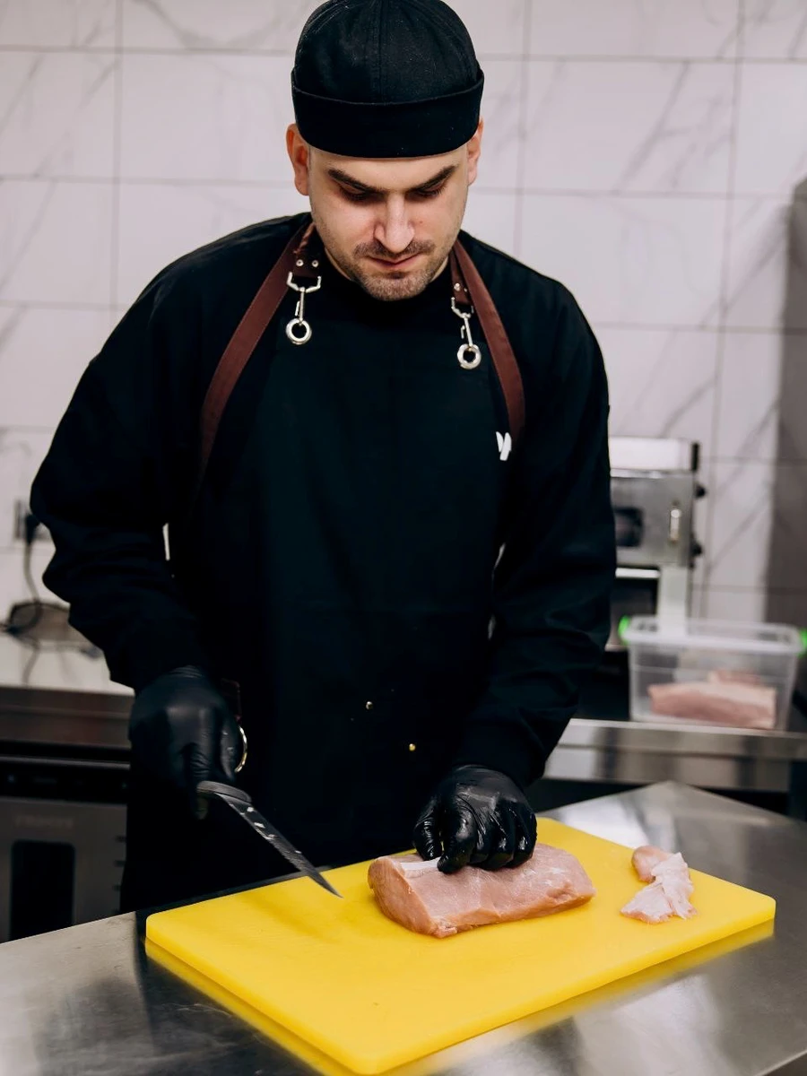 Иван Цигрик работает с мясом в цехе